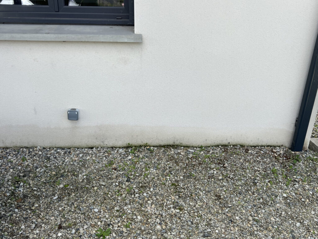 Façades Ariégeoises avec mur blanc et prise électrique en bas à gauche.