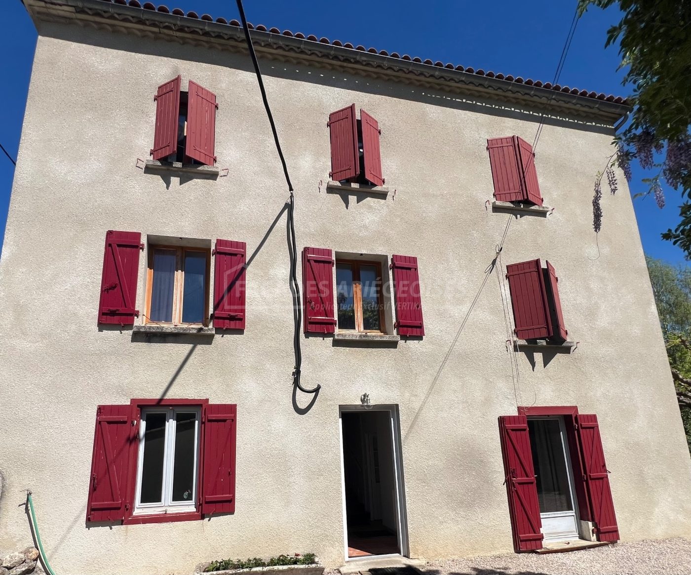 Façade ariégeoise avec volets rouges et fenêtres