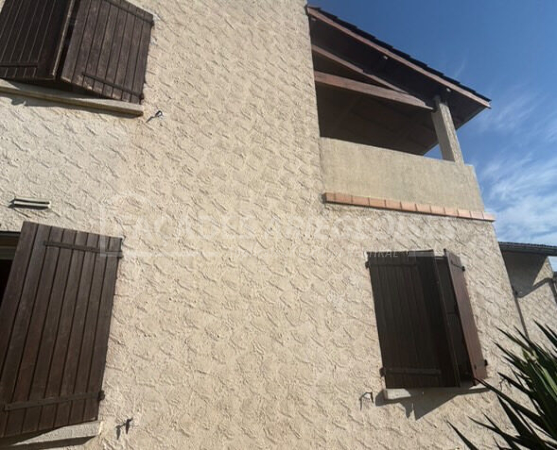 Façades Ariégeoises avec volets en bois et textures murales.