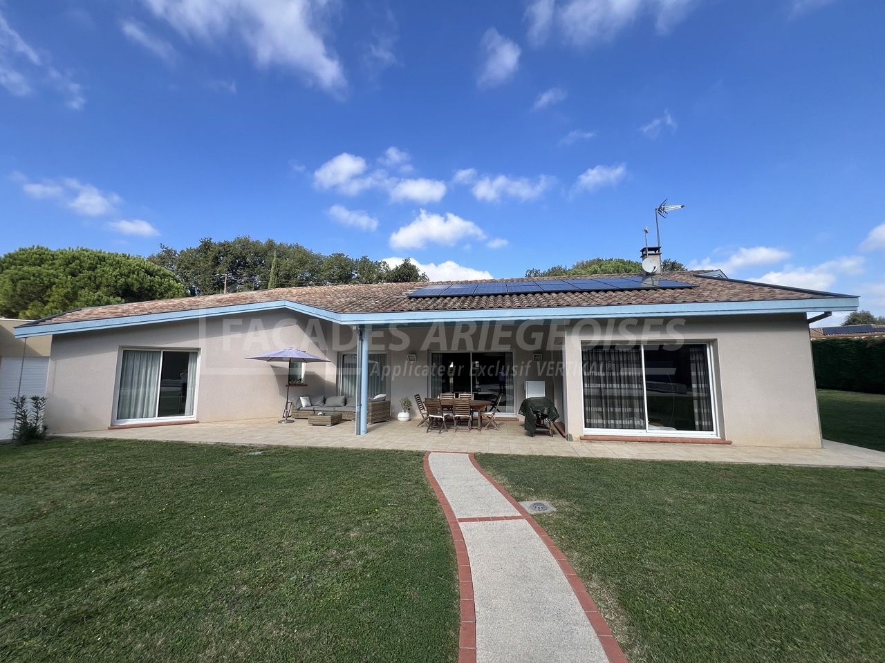 Façades Ariégeoises d'une maison moderne avec terrasse et jardin.